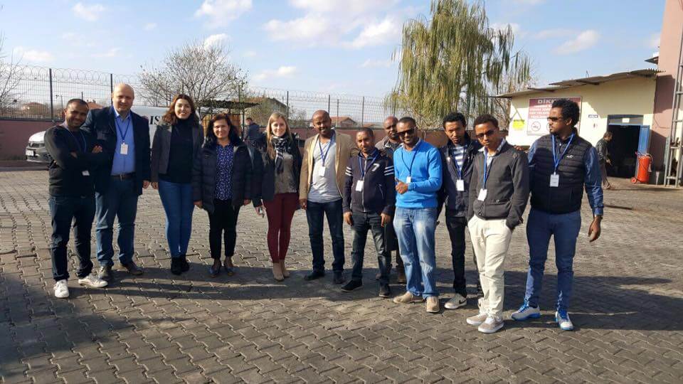Two business people shaking hands across a boardroom table in Ethiopia